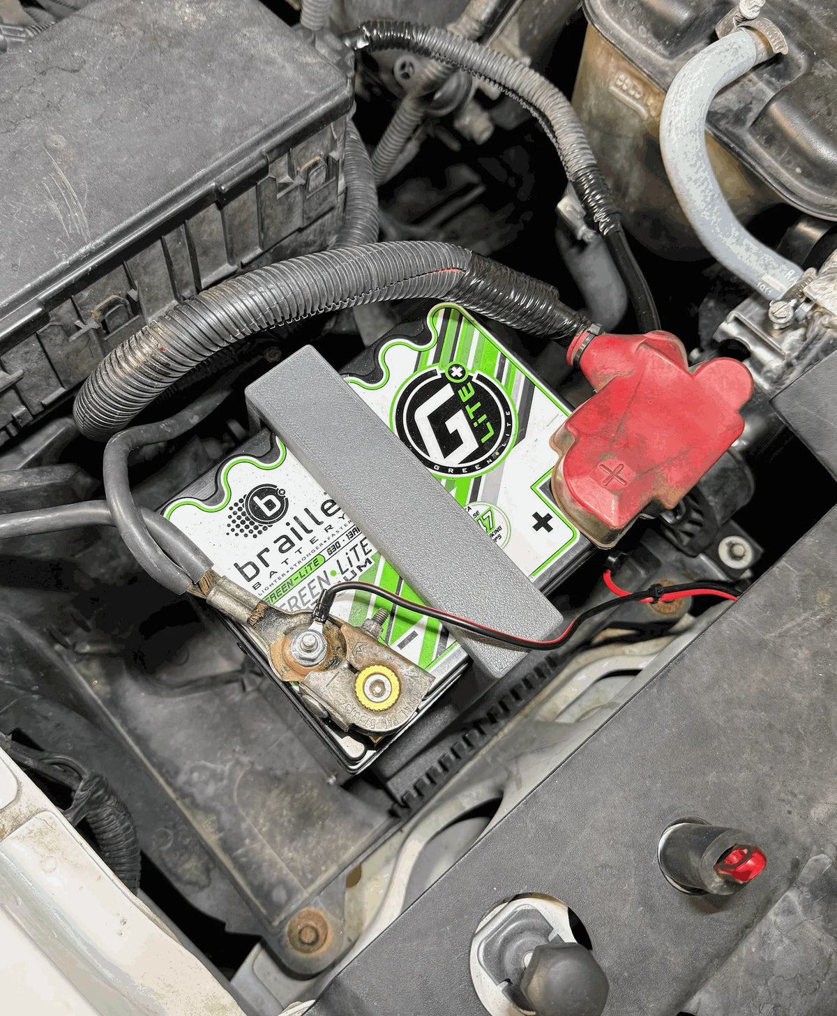 Battery hold-down installed over a Braille G30 lithium battery in the factory Group 65 battery tray